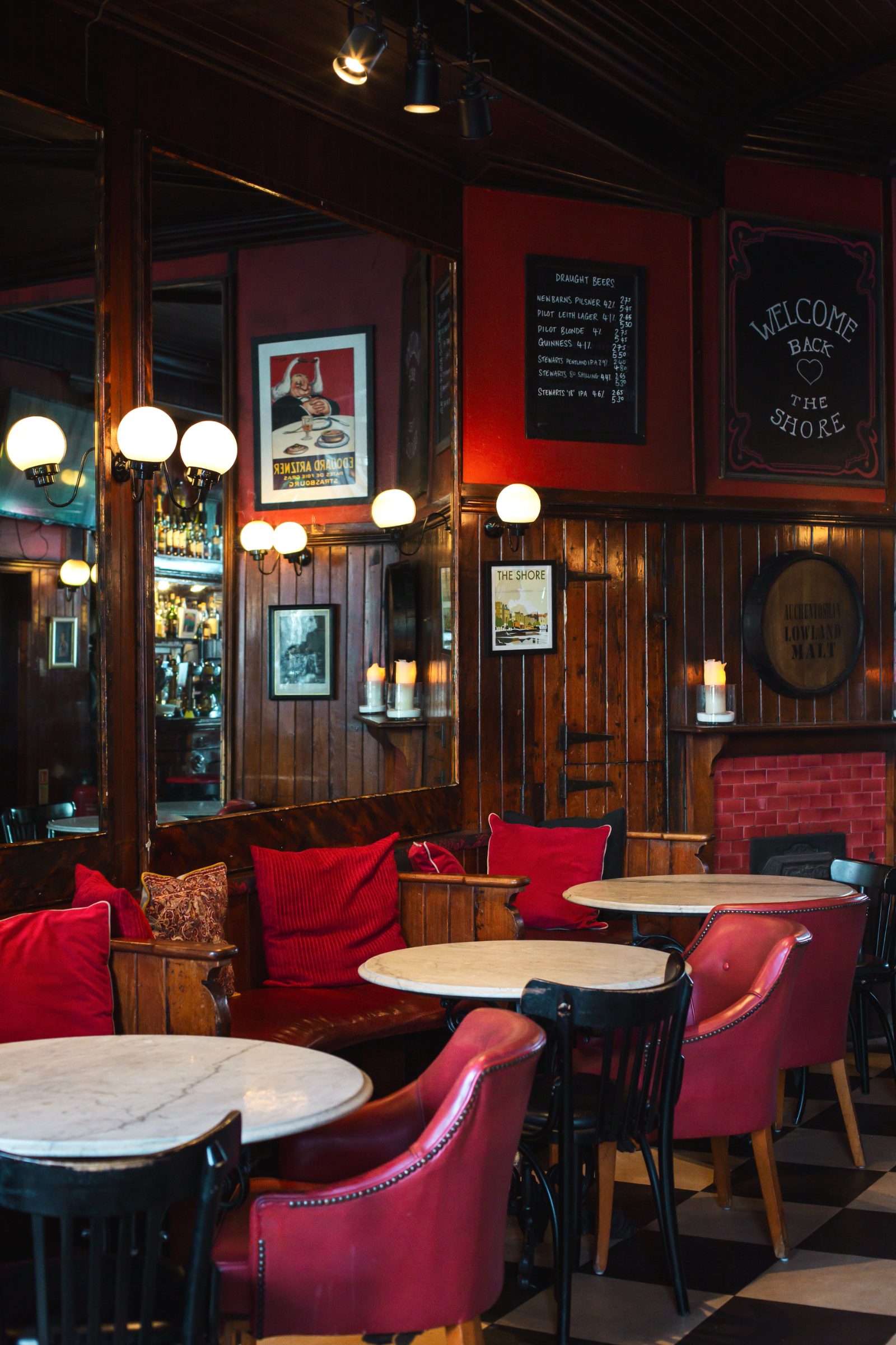 The wood-panelled bar room at The Shore, Leith — red leather chairs and marble tables
